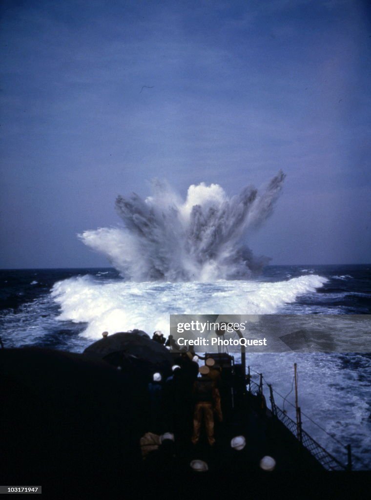 Depth Charges Exploding Sailors stand on deck and watch as a depth charge explodes in the ...