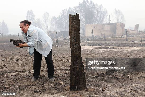 Valentina Chelysheva holds her burned hen found by her house on July 30, 2010 in Verkhnyaya Vereya, Russia. Putin visited the village where all 341...