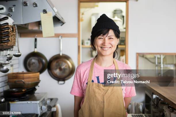 a woman owner who shows a proud smile in the kitchen - self satisfaction foto e immagini stock