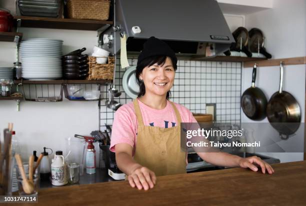 a woman entrepreneur who shows a smile at the counter - woman smile kitchen foto e immagini stock