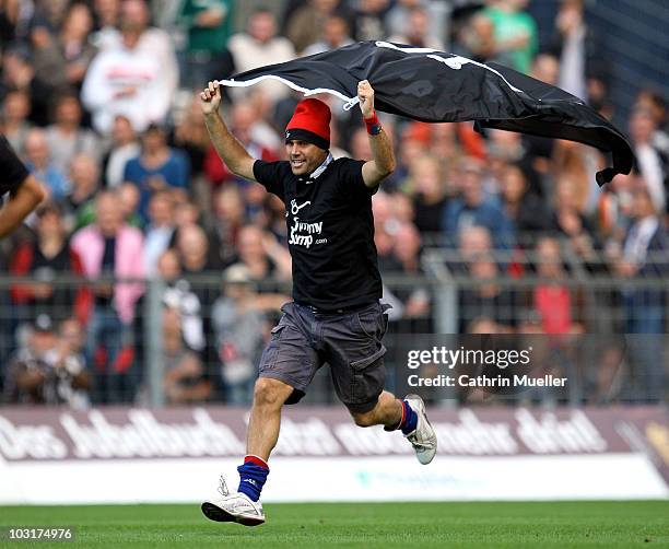 Fan runs over the pitch during the pre-season friendly match between FC St. Pauli and Racing Santander at Millerntor Stadium on July 30, 2010 in...