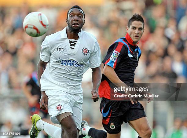 Richard Sukuta-Pasu of FC St. Pauli battles for the ball with Jose Antonio Picon of Racing Santander during the pre-season friendly match at...