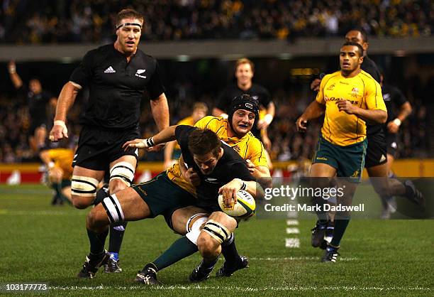 Richie McCaw of the All Blacks crosses for a try although being tackled by Dean Mumm of the Wallabies during the 2010 Tri-Nations Bledisloe Cup match...