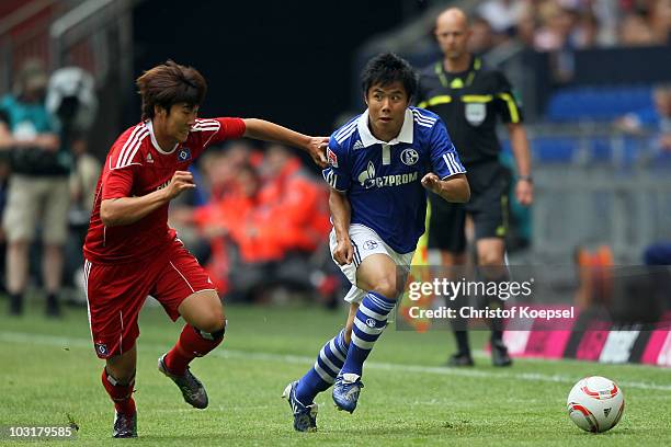 Heung-Min San of Hamburg tackles Hao Junmin of Schalke during the LIGA total! Cup 2010 match between FC Schalke 04 and Hamburger SV at the Veltins...