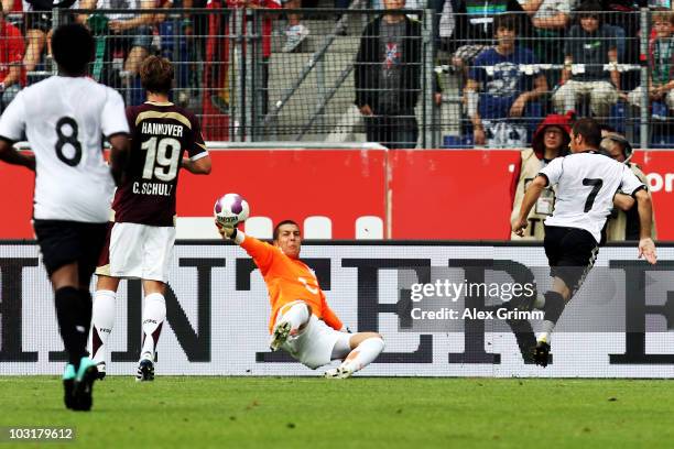 Joaquin Sanchez Rodriguez of Valencia scores his team's second goal against goalkeeper Florian Fromlowitz of Hannover during the pre-season friendly...