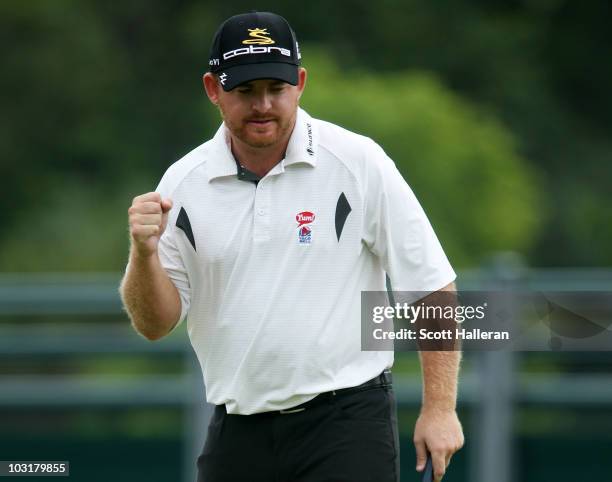 Holmes celebrates as he holes a putt for birdie on the 18th green to finish with a ten-under par 60 during the third round of the Greenbrier Classic...