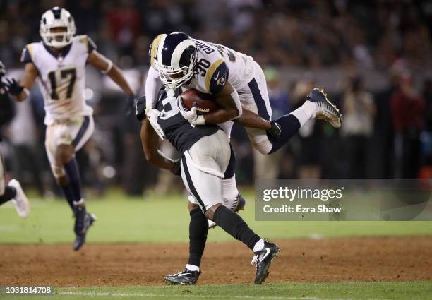 Todd Gurley of the Los Angeles Rams is tackled by Marcus Gilchrist of the Oakland Raiders at Oakland-Alameda County Coliseum on September 10, 2018 in...