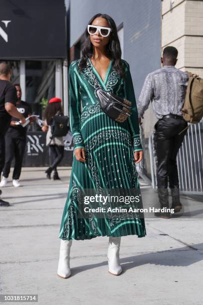 Janelle Lloyd is seen wearing a green Sandro Dress and white boots on the street during New York Fashion Week on September 11, 2018 in New York City.