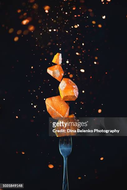 golden marmalade block on a fork with sparks and flares. action food photography on a dark background with copy space. gourmet dessert concept. - alta moda fotografías e imágenes de stock
