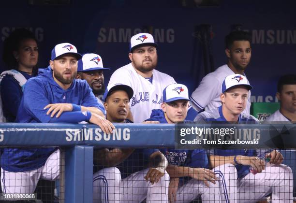 Rowdy Tellez of the Toronto Blue Jays looks on from the dugout alongside head athletic trainer Nikki Huffman and Kevin Pillar and Dwight Smith Jr....