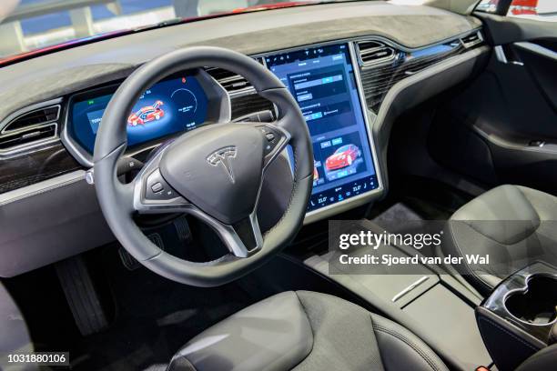 Luxurious interior on a Tesla Model S full electric luxury car with a large touch screen and dashboard screen. The car is fitted with leather seats...