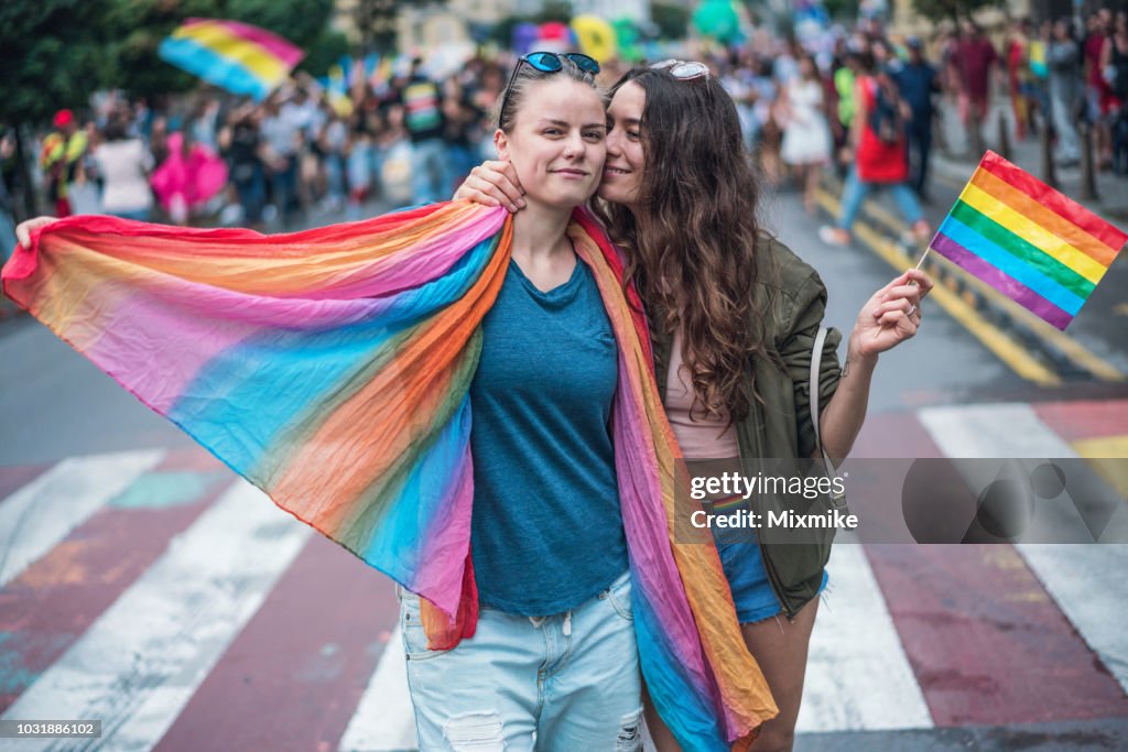 Casal feliz feminino abraços e beijos na parada do orgulho gay