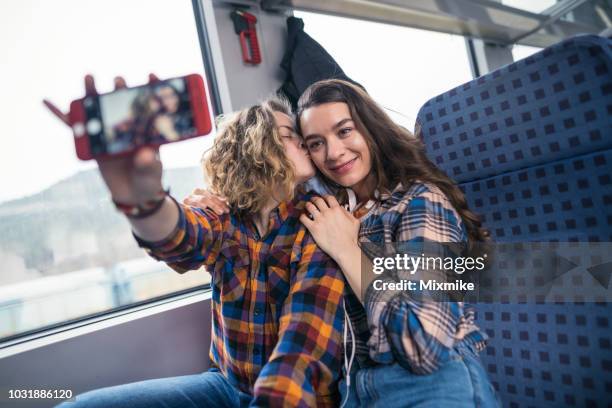 lovely couple making selfies in the train while travelling - photos of lesbians kissing stock pictures, royalty-free photos & images