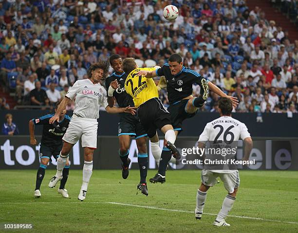 Martin Demichelis of Bayern, Joel Matip of Schalke, Rouven Sattelmeier of Bayern and Kyriakos Papadopoulos of Schalke go up for a header during the...