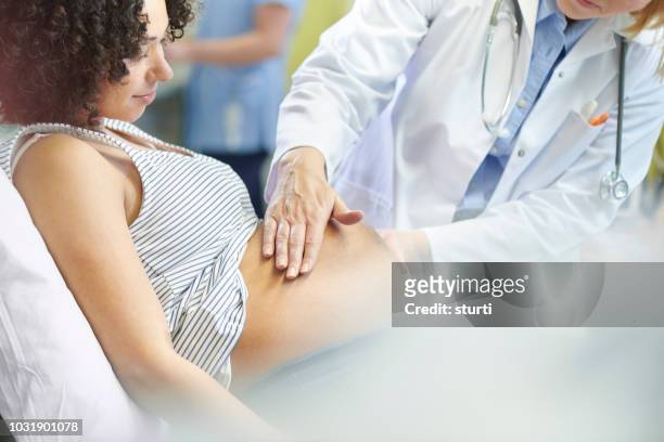 pränatale check in der klinik - pregnant woman at doctor stock-fotos und bilder