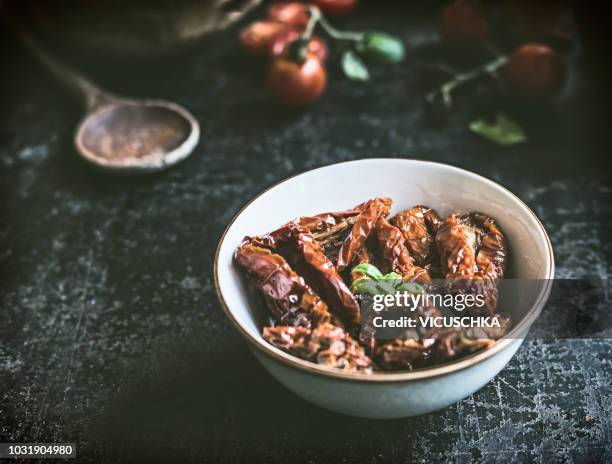 sun-dried tomatoes in bowl with olives oil - sonnengetrocknete tomate stock-fotos und bilder