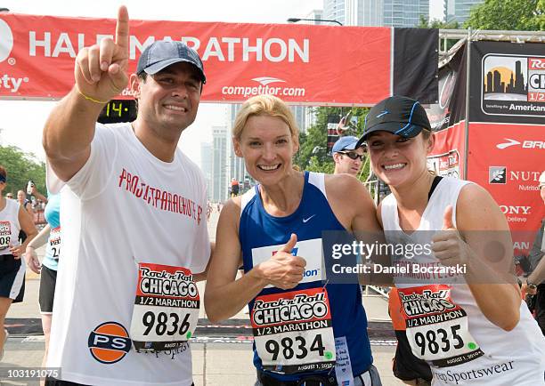 Jason Mesnick, Andrea Powell and Molly Mesnick celebrate after crossing the finish line at the Rock 'n' Roll Chicago Half Marathon on August 1, 2010...