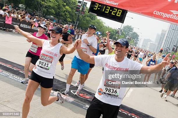 Jason Mesnick and Molly Mesnick cross the finish line at the Rock 'n' Roll Chicago Half Marathon on August 1, 2010 in Chicago, Illinois.