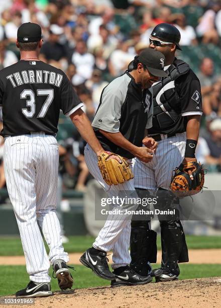 Manager Ozzie Guillen of the Chicago White Sox laughs after being swiped by pitcher Matt Thorton after taking Thorton out of a game as Ramon Castro...