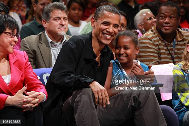 President Barack Obama and daughter Sasha Obama share a moment during the game between the Washington Mystics and the Tulsa Shock at the Verizon...