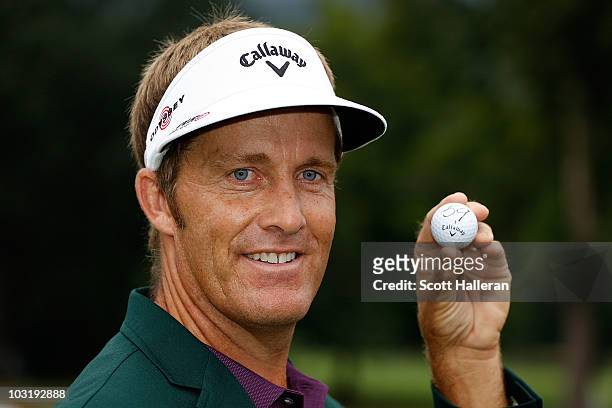 Stuart Appleby of Australia poses with his golf ball after he finished with an 11-under par 59 during the final round of the Greenbrier Classic on...