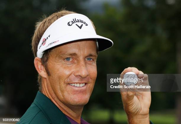 Stuart Appleby of Australia poses with his golf ball after he finished with an 11-under par 59 during the final round of the Greenbrier Classic on...