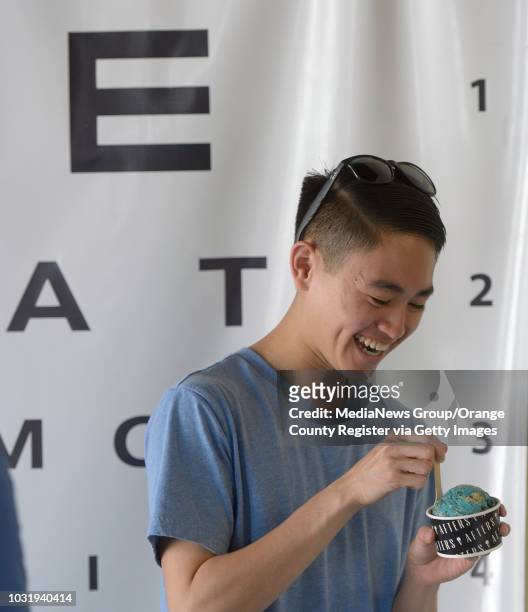 Brandon Huynh digs in to his scoop of cookie monster ice cream at Afters in Fountain Valley on Wednesday. The ice cream shop features flavors like...