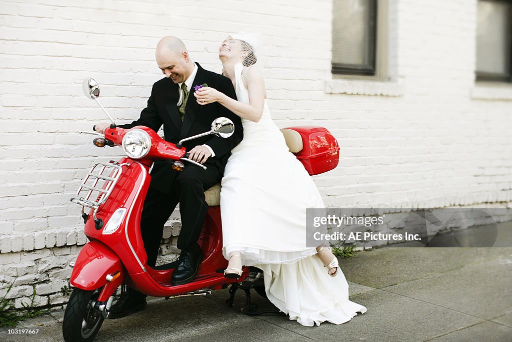 Bride and groom on red motorbike