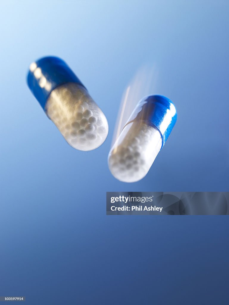 2 capsule pills on a blue background