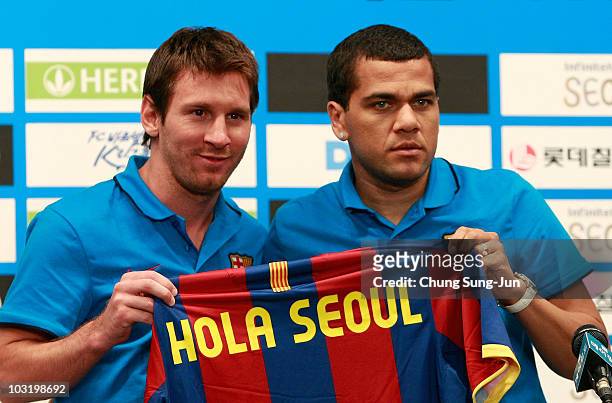 Lionel Messi and Daniel Alves of Barcelona hold a jersey during a press conference at the Mayfield hotel on August 2, 2010 in Seoul, South Korea. FC...