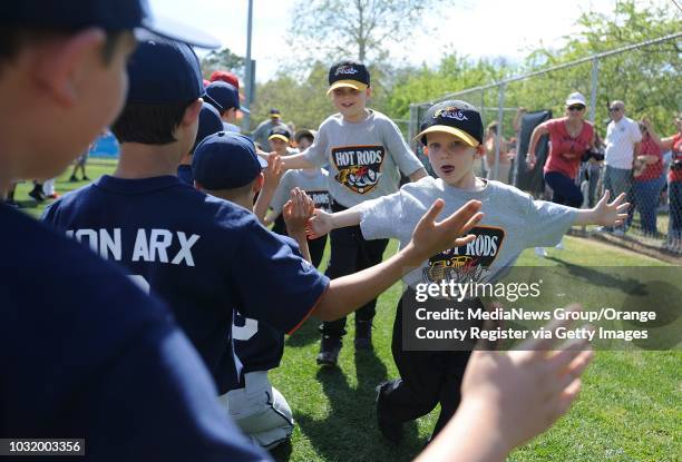 Ballers get high-fives from older players as they enter opening ceremonies for The Los Altos Youth Baseball and Softball league at El Dorado Park in...