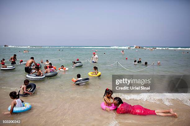 Palestinian children from the West Bank village of Jahalin play in the water as they spend the day at the beach on August 2, 2010 in Bat Yam, Israel....