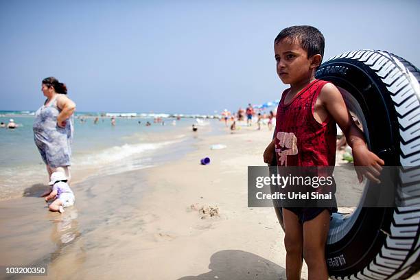 Palestinian boy from the West Bank village of Jahalin looks on, as he spends the day at the beach on August 2, 2010 in Bat Yam, Israel. A group of...