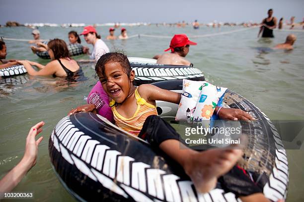 Palestinian girl from the West Bank village of Jahalin plays in the water as she enjoys a day at the beach on August 2, 2010 in Bat Yam, Israel. A...