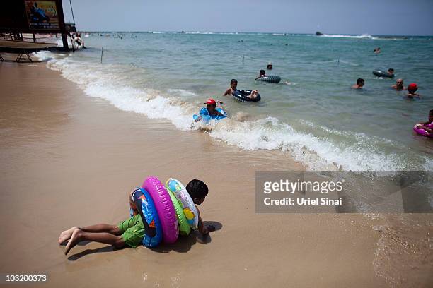 Palestinian children from the West Bank village of Jahalin play in the water as they spend the day at the beach on August 2, 2010 in Bat Yam, Israel....