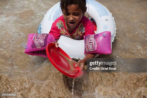 Palestinian girl from the West Bank village of Jahalin spends the day at the beach on August 2, 2010 in Bat Yam, Israel. A group of Israeli women...