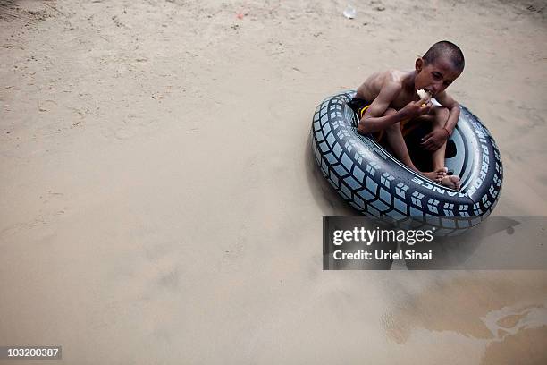 Palestinian boy from the West Bank village of Jahalin, sits in a tube as he spends the day at the beach on August 2, 2010 in Bat Yam, Israel. A group...