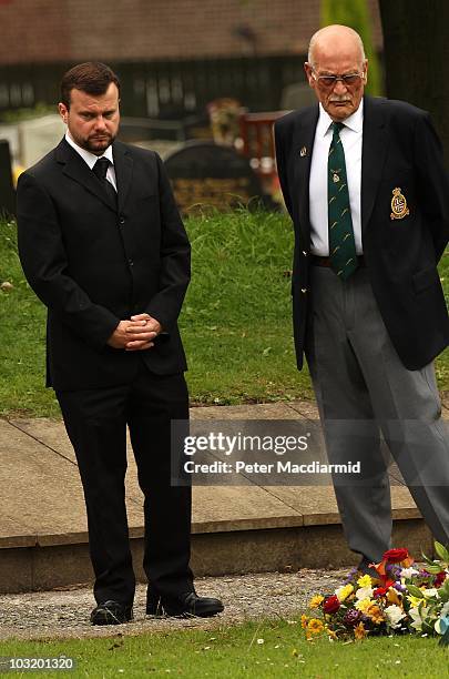Angus Moat looks at floral tributes after the funeral of his brother Raoul Moat as his uncle Charlie Alexander looks on at West Road Crematorium on...