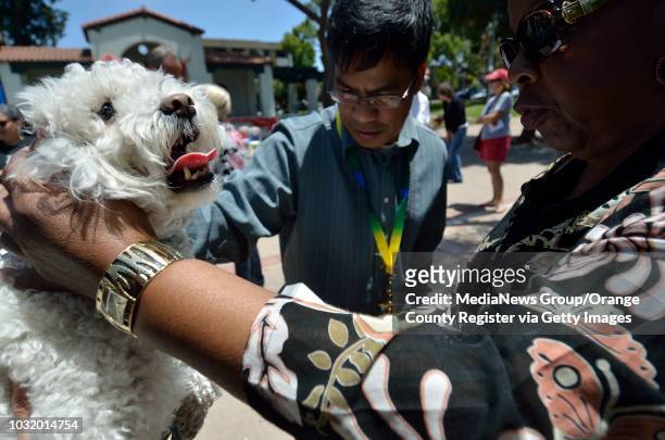 United Methodist clergy Rev. Nestor Gerente, Rev. Mary Walton bless animals, including Lauri Raykoff's dog Baily, during a fund-raiser for dog...
