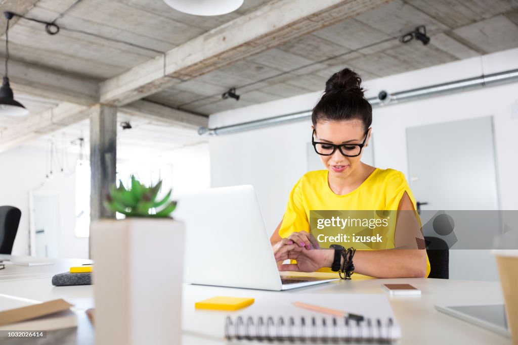 Female designer checking time in office