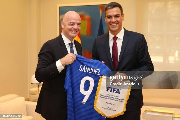 President Gianni Infantino gives a jersey to Prime Minister of Spain Pedro Sanchez as a present during their meeting at Moncloa Palace on September...