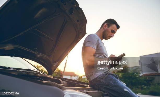 mann neben einem aufgeschlüsselt auto - unfall stock-fotos und bilder