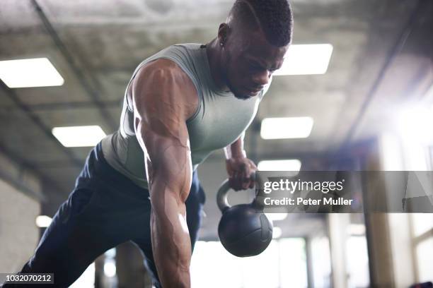 man doing plank with kettlebells in gym - strong black man stock pictures, royalty-free photos & images