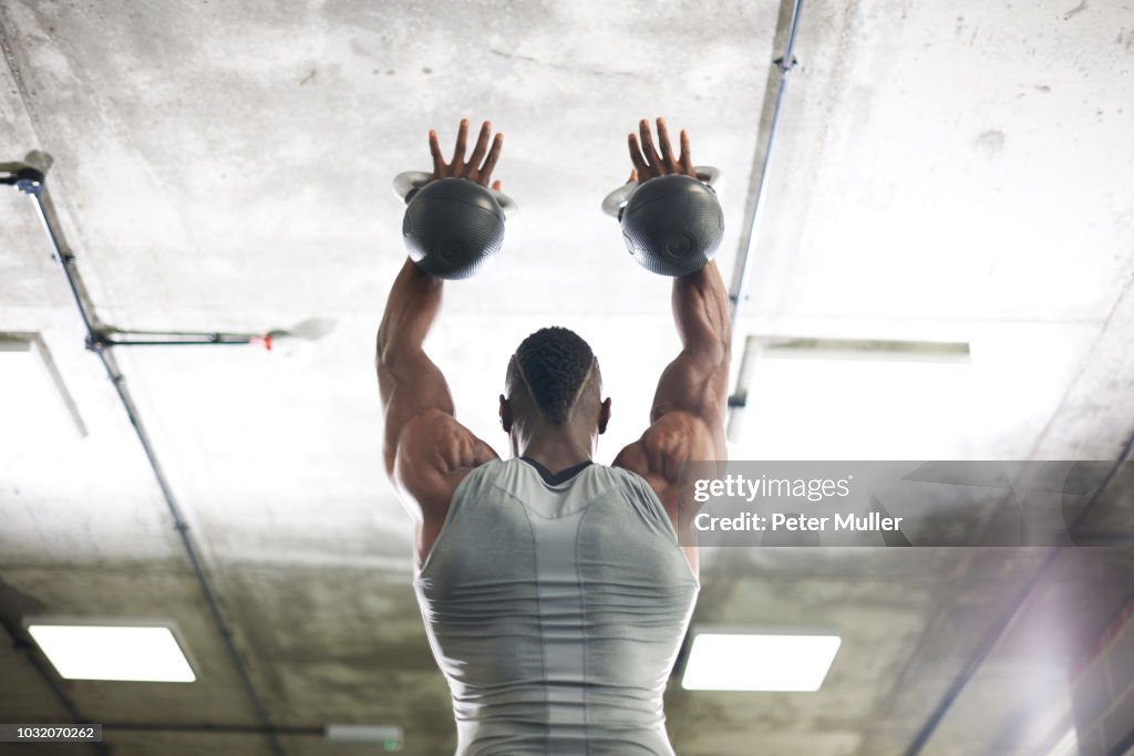 Man lifting kettlebells in gym