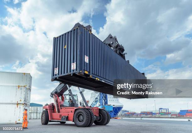 container lift with shipping container in port - immingham stock pictures, royalty-free photos & images