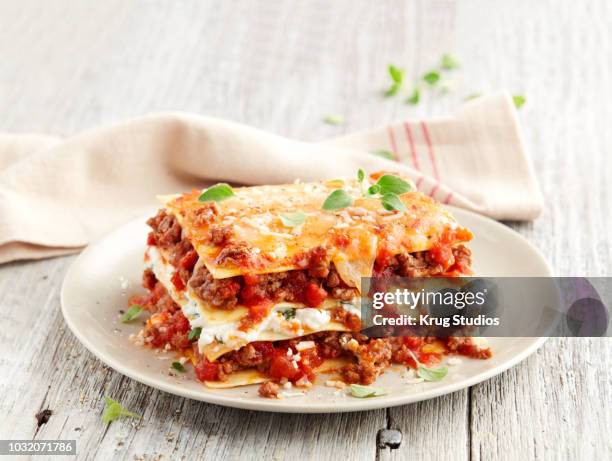 beef lasagna slice on a plate on wood - lasagne stock pictures, royalty-free photos & images