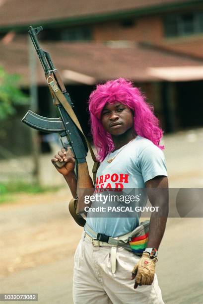 Rebel loyal to warlord Charles Taylor of the National Patriotic Front of Liberia wearing a wig, patrol 21 July 1990 in Schiefflin during the fighting...