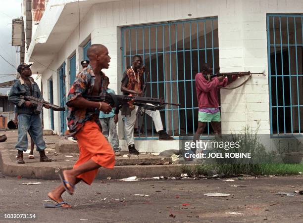 Group of heavily-armed ethnic Krahn fighters loyal to Liberian warlord Roosevel Johnson fire at a position held by National Patriotic Front of...