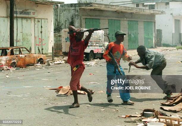 Fighters for the forces loyal to Charles Taylor and Alhaji Kromah aim at Krahn faction members 18 May in the streets of Monrovia. New fighting broke...