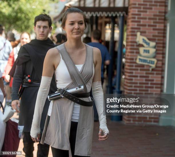 Sarah Berry, dressed as Rey, followed by Alex Hazen, dressed as Kylo Ren, walk down Main Street U.S.A. At Disneyland in Anaheim, California, on...